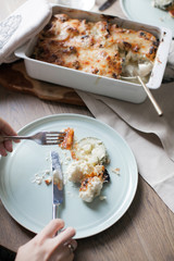 Vegetable casserole of cauliflower and zucchini. Laid dinner table. Plates with cutlery. Dietary food.