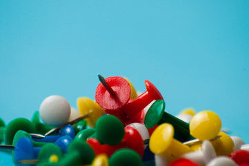 Obraz premium Multicolored push pins on a blue background macro closeup