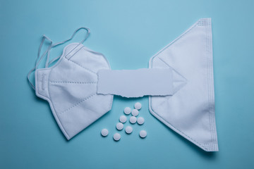 pills and protective mask on a blue background