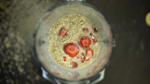 Ring of strawberries. The red berry falls into the milk in the blender bowl. Ice cream with oatmeal and bananas. Healthy vegetarian food. Smoothies drinks food in the mixer. Healthy food from fruits a