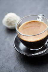 Coffee in glass cup on dark stone background. Close up.	