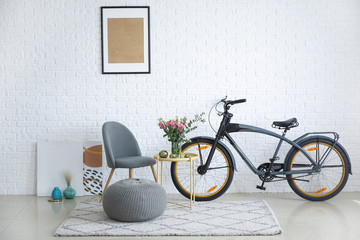 Interior of modern room with comfortable chair, table and bicycle