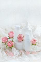 Beauty care cosmetic products. bottles with lotion and cream, rose flowers. spa healing procedures concept. copy space