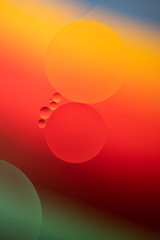 Abstract view of oil drops in water and coloured paper