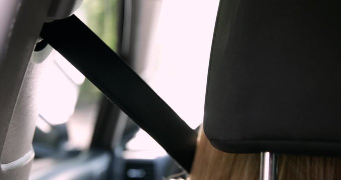 woman fastening car safety seat belt while sitting inside of vehicle before starting engine