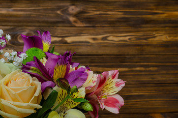 Bouquet of flowers from alstroemeria and roses on a wooden background