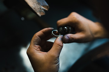 Fototapeta premium Master of jewelry while working on making a gold ring. Top view. 