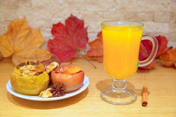 Homemade warm autumn drink beverage and tasty baked apples with cinnamon and spices.