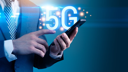 The abstract image of businessman using a smartphone overlay with 5g and cityscape hologram. the concept of 5G, communication, network, connection, internet of things.