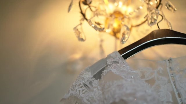 A close-up shot of the shoulder lace detail on a crystal-embellished lace bodice of a wedding gown