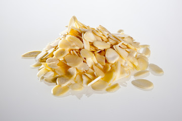 Heap of sliced peeled almonds in the white background