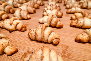 Small homemade nut croissants on a wooden table