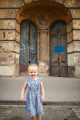 Obraz na płótnie Canvas little happy girl in background of old door