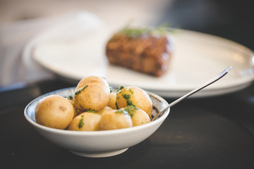 Close up images of a side of boiled potatoes being served in a gourmet restaurant