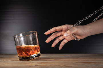 Alcoholism concept . Hands lock chain a glass of whiskey To stop drinking . Stop alcohol addiction...