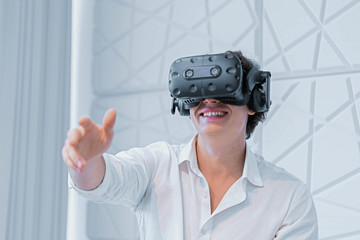 Smiling Man Touching Air By Stretched Hand At VR Conference or Presentation. Answering Question Of Online Viewers at Scene. Conference With Social Distancing