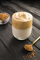 Dalgona coffee in the glass  in the black wooden  background. Location vertical.