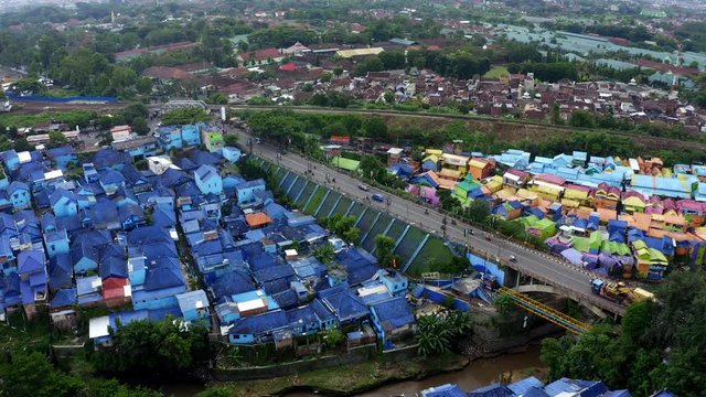 Blue roofs and rainbow village in background, Aerial orbit shot