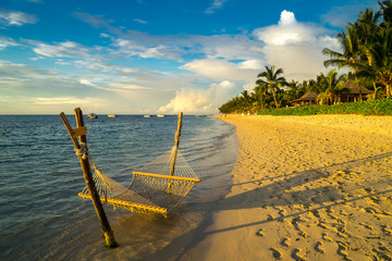 A hammock on the beach against a background of clouds, the ocean and an incredible sunset....