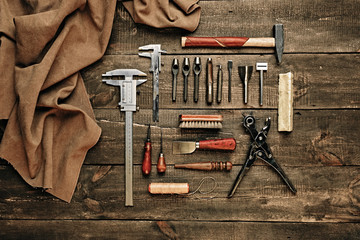 Flat lay composition with leather samples and set crafting DIY tools on wooden table background...