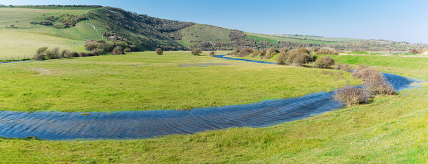 Walk to Cuckmere Haven beach near Seaford, East Sussex, England. South Downs National park. View of blue waters of the river, birds, panorama, long photo banner, selective focus