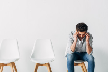 Thoughtful man waiting for job interview on chair in office