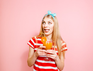 Happy blonde who drinks lemonade and smiles pleasantly on pink background.