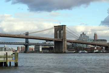 Fototapeta na wymiar New york, USA - 20.12.2019: Brooklyn bridge in New York, Manhattan skyscrapers skyline behind across Hudson river at end of day New York, USA - stock photo