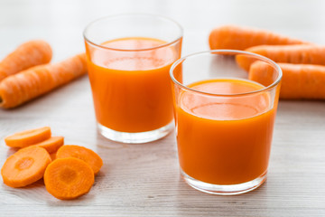 Two glasses with carrot juice on the table.