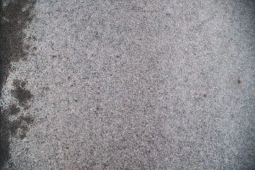 Grey road asphalt texture with wet surface on the left side