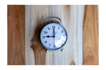 Gray alarm clock on a wooden table.