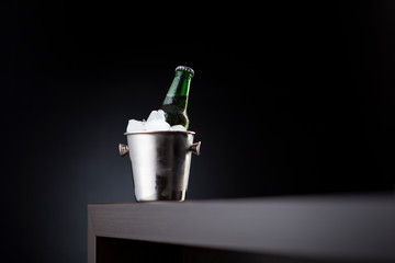Beer bottle in an ice bucket on bar counter