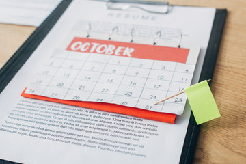 Selective focus of flag on calendar near resume on wooden table