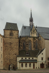Medieval fortress tower and bell tower in the Baroque style decorated with a clock. Altenburg. Germany. Soft focus, blurry background.