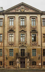 Fragment of the facade of an old castle. Stucco, bas-reliefs, plaster defects. Altenburg. Germany. Soft focus, blurry background.