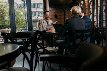 Business people holding a meeting at office cafeteria discussing about business plan.