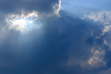 Naklejka na ściany i meble Sunbeam, sunlight through the haze, cloud on the blue sky . Cloud with sun ray.