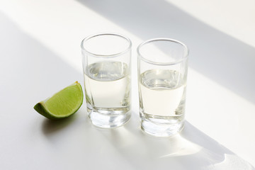two shots of tequila and lime in sunny Lights