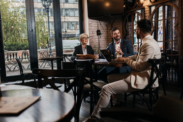 Business people holding a meeting at office cafeteria discussing about business plan.