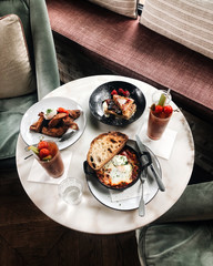 Brunch classics featuring shakshuka, pastries, bloody mary, french toast, eggs and soughdough