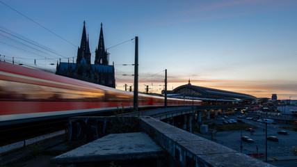 Fototapeta premium Ankunft Zug am kölner Hauptbahnhof in Köln bei Sonnenuntergang am Abend