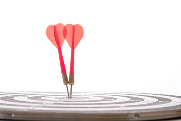 Two red arrow dart hit to center of target board on blue bokeh background. Business investment...