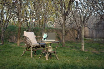 Fototapeta premium Good place to work at home with laptop in green garden, during the covid epidemic