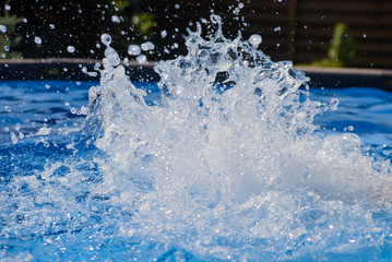 Spray in water in blue in a frame pool