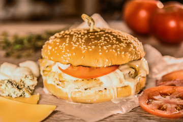 Appetizing hamburger on a table among vegetables