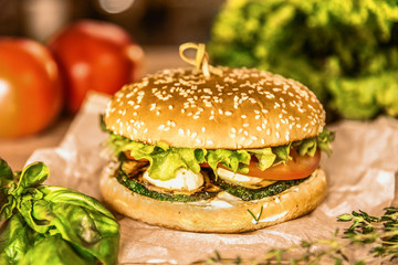 Appetizing hamburger on a table among vegetables