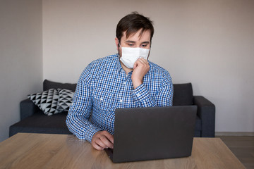 man wearing mask working on his laptop from home , coronavirus, illness, infection, quarantine, medical mask