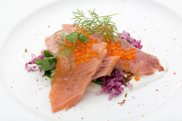 A closeup of salmon with caviar on a white background