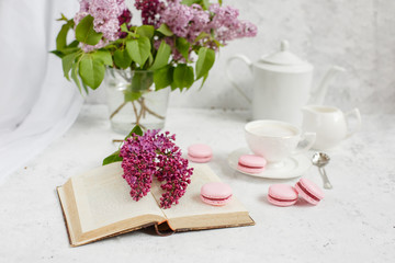 Obraz na płótnie Canvas A Cup of morning coffee, a bowl of lilac, macaroni, on a light background. Postcard good morning