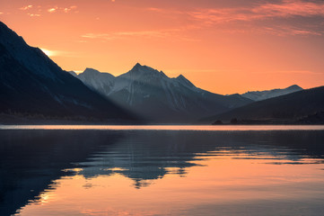 Sunrise on rocky mountains with colorful sky on Medicine Lake, Jasper national park